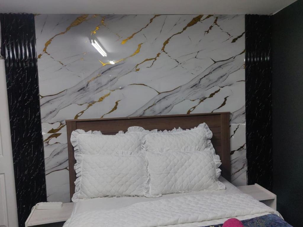 a bedroom with a bed with a marble wall at Camp Inn Lodge in Pietermaritzburg