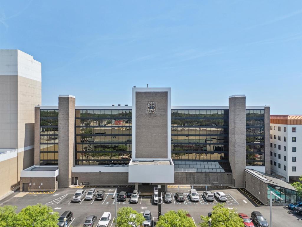 a parking lot in front of a building with a clock tower at The Barclay Towers Hotel and Resort in Virginia Beach