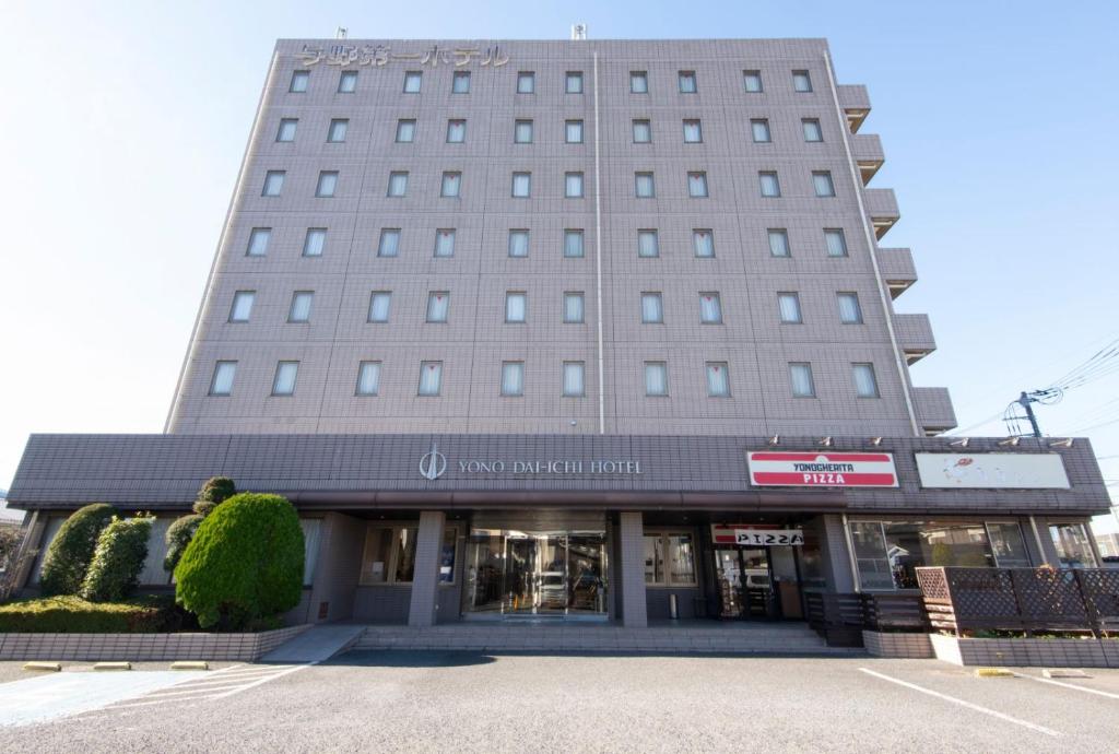 a tall building with a store in a parking lot at Yono Daiichi Hotel in Saitama