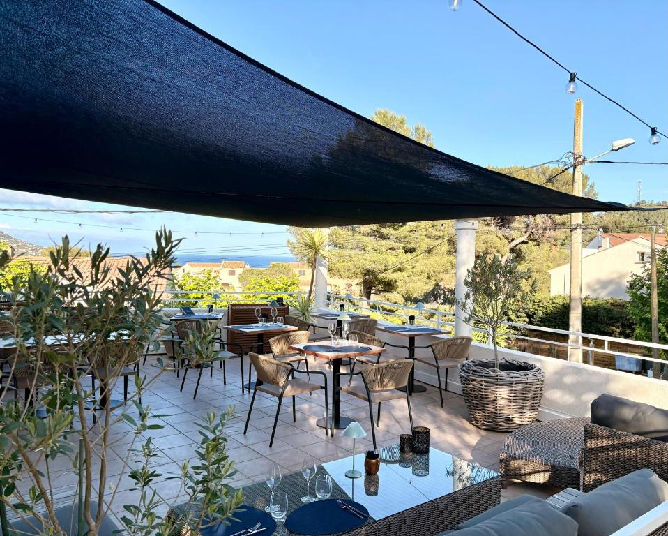 a patio with tables and chairs on a balcony at Hôtel Le Clos du Dramont in Saint-Raphaël