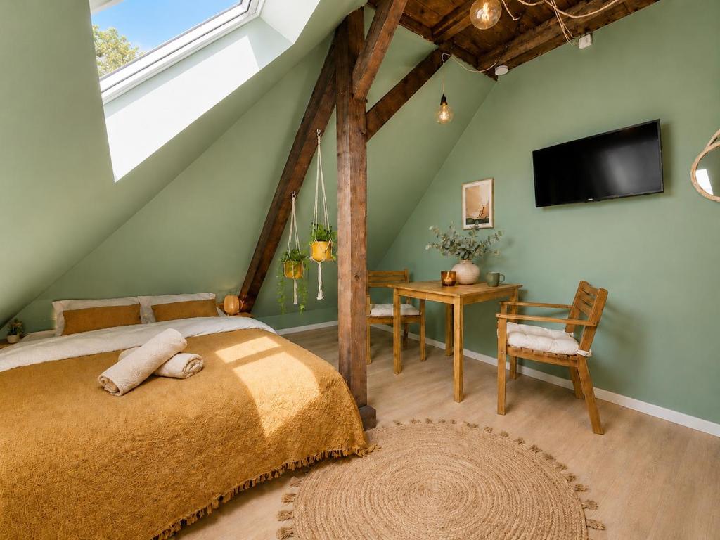 a bedroom with a bed and a tv and a table at Cabane urbaine in Sarreguemines