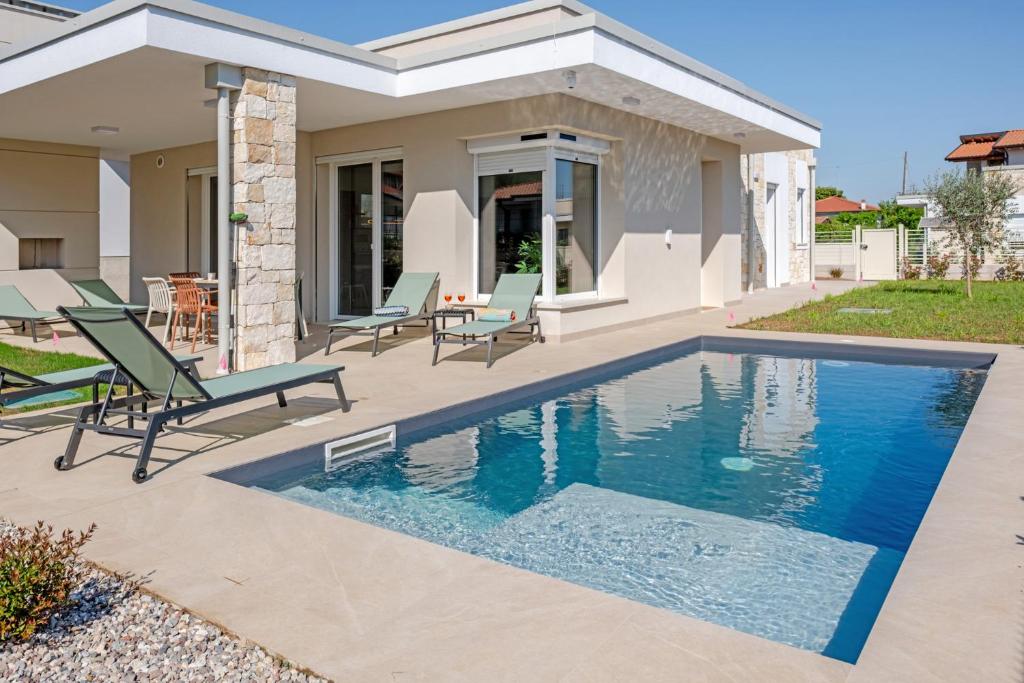 a swimming pool in front of a house at Villa Milvia in Colà di Lazise