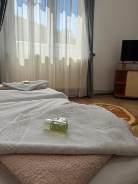 a bottle on top of a bed in a room at Motel Vatra Bunătăților in Brezoi