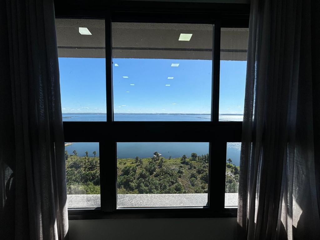 a window with a view of the ocean at Flat Praia da Graciosa in Palmas