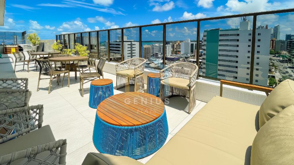 a balcony with a table and chairs on a roof at Compact Tambaú Genius Flats in João Pessoa