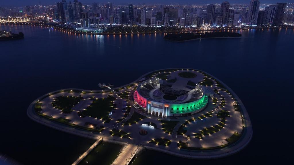an island with lights in the water at night at Double Room with Private Bathroom near Dubai in Sharjah