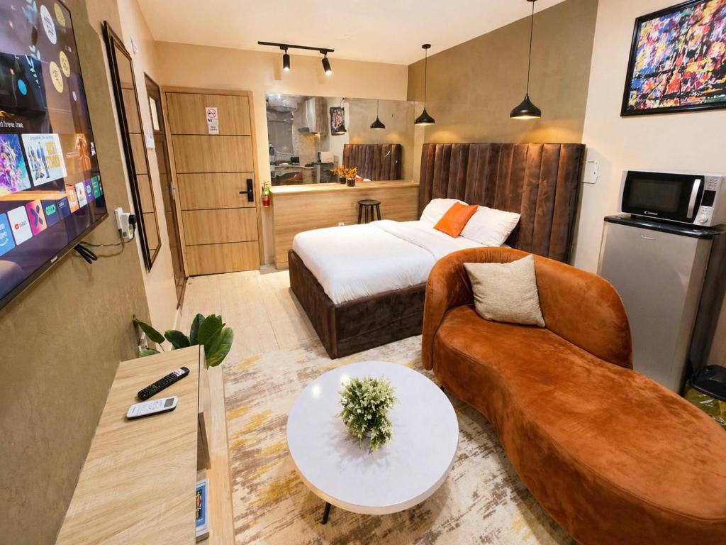 a hotel room with a bed and a couch at Happy Lodge Shortlets & Suites, Freedom Way, Lekki phase 1 in Ogoyo