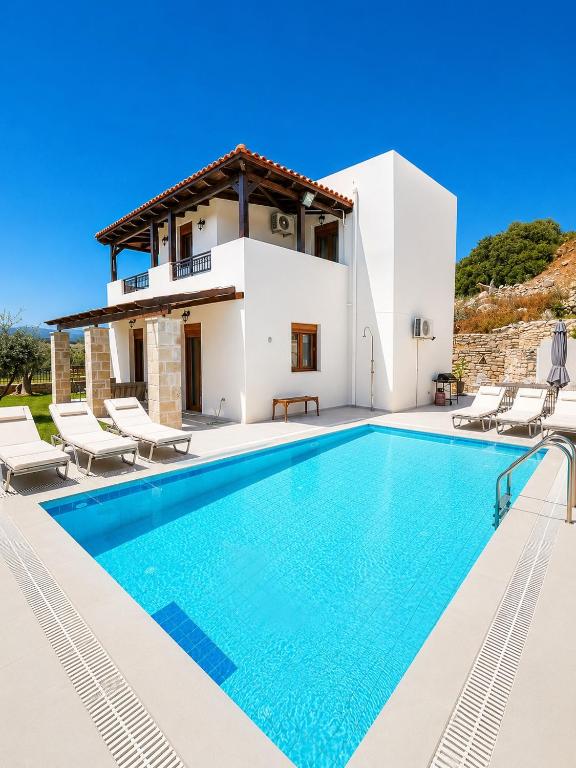 a villa with a swimming pool in front of a house at Villas Roumeli in Roumelí