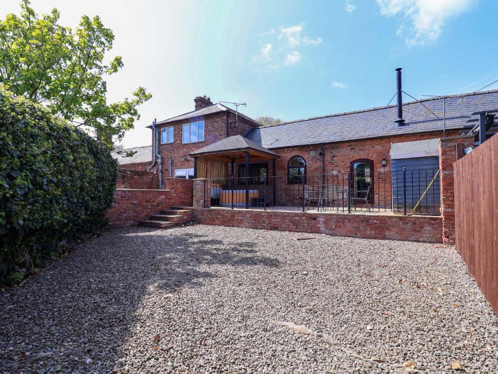 a brick house with a driveway in front of it at Clwyd Cottage in St Asaph
