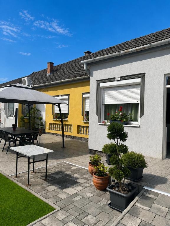 a patio with a table and an umbrella at Viktor Apartmanház in Zamárdi