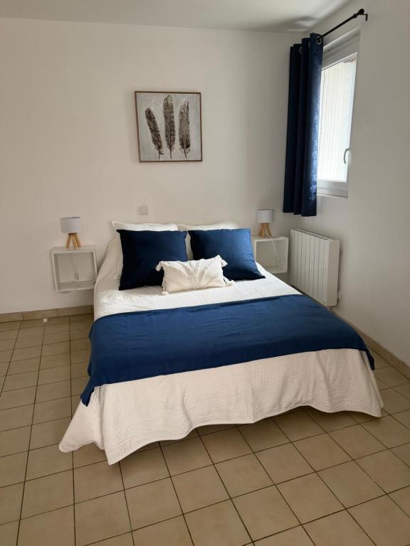 a bedroom with a large bed with blue and white sheets at Gites des Lavandières in Cour-Cheverny