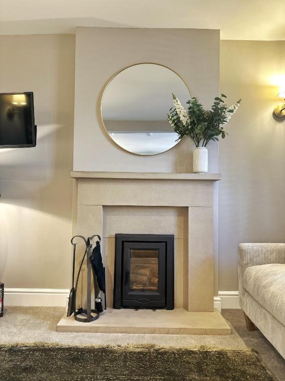 a living room with a fireplace and a mirror at No 3 Chapel Row in Bakewell