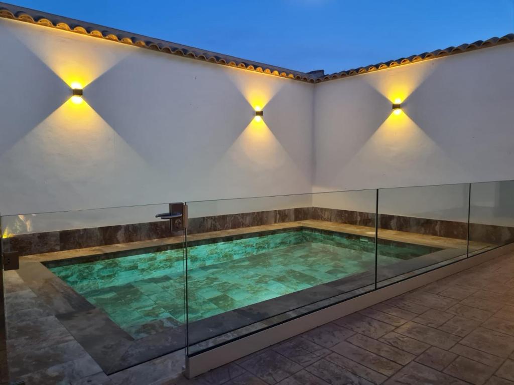 a pool in a building with lights on the wall at En Ca La Abuela Casa Rural in Consuegra