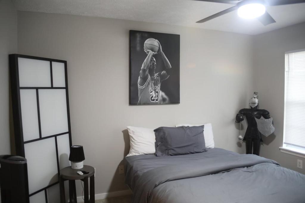 a bedroom with a bed with a skeleton picture on the wall at #HycheHoops Final Four Nest in Starkville