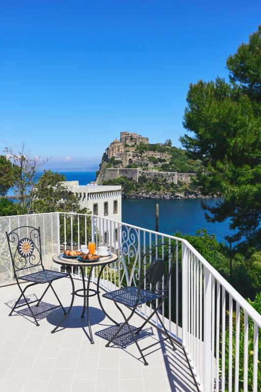a table and chairs on a balcony with a view of the water at Don Felipe Boutique Hotel in Ischia Town