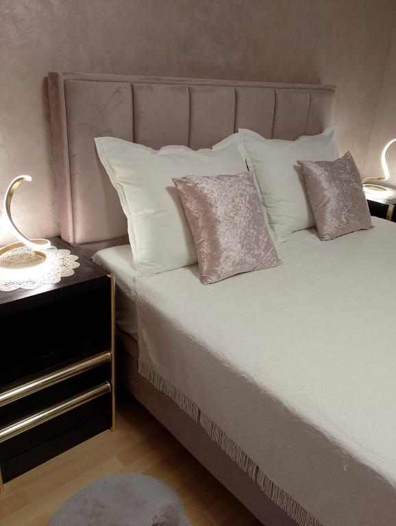 a bedroom with a bed with pillows and a night stand at Apartmani Diva in Malinska