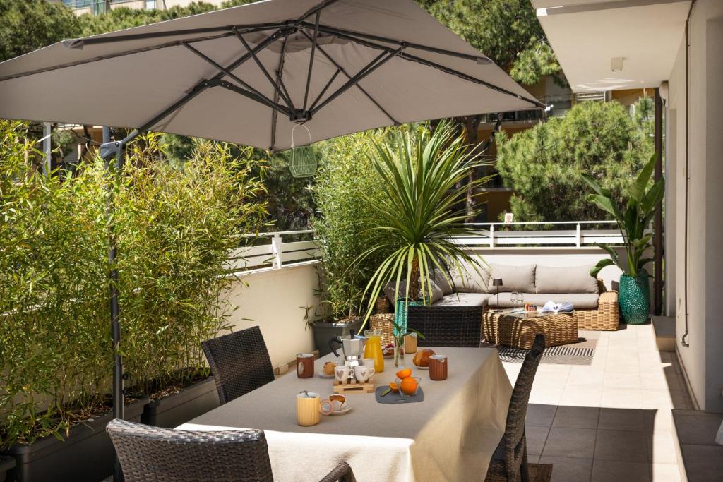 a patio with a table and an umbrella at The Iconic Ceccarini - Riviera Collection in Riccione
