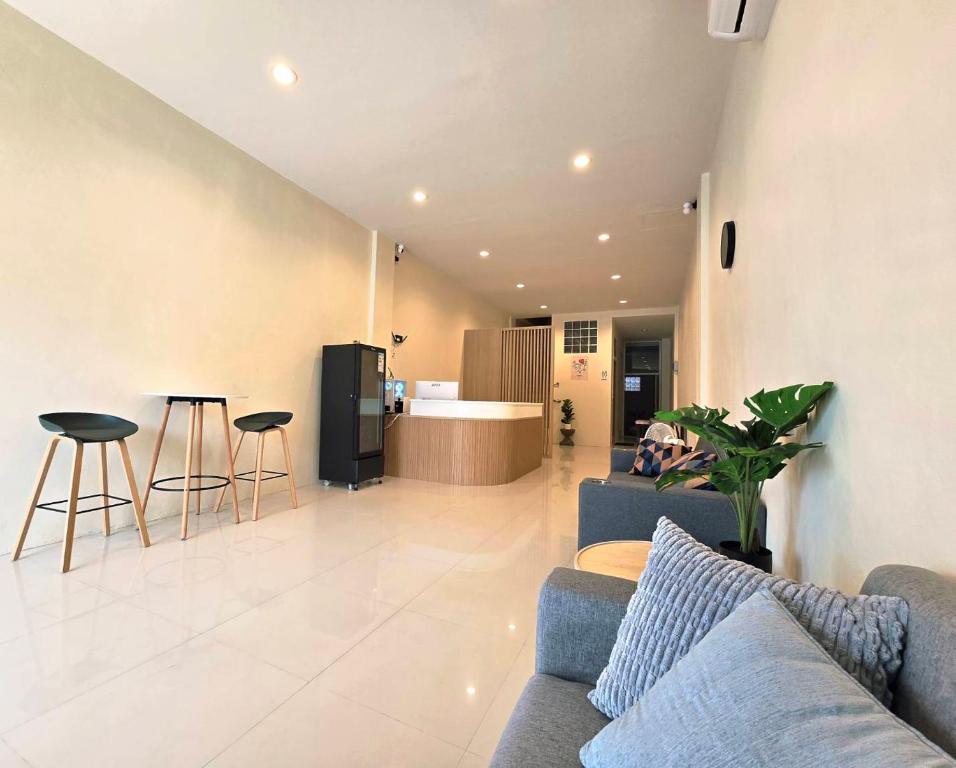 a living room with a couch and a kitchen at Buddy Hostel in Chiang Rai