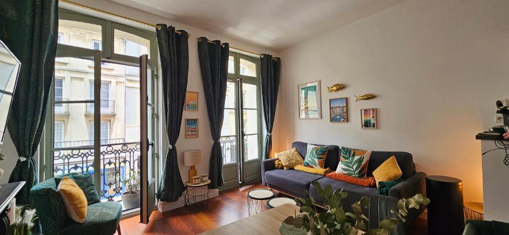 a living room with a couch and a balcony at Les balcons de Dieppe - appartement 1ER étage - certifié 3 étoiles au cœur de la rue piétonne in Dieppe