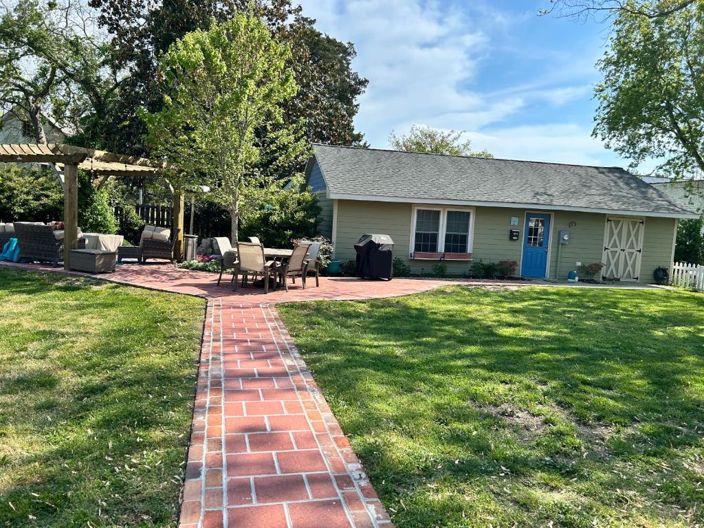 a house with a brick walkway in the yard at Chucks Cottage in Cape Charles in Cape Charles
