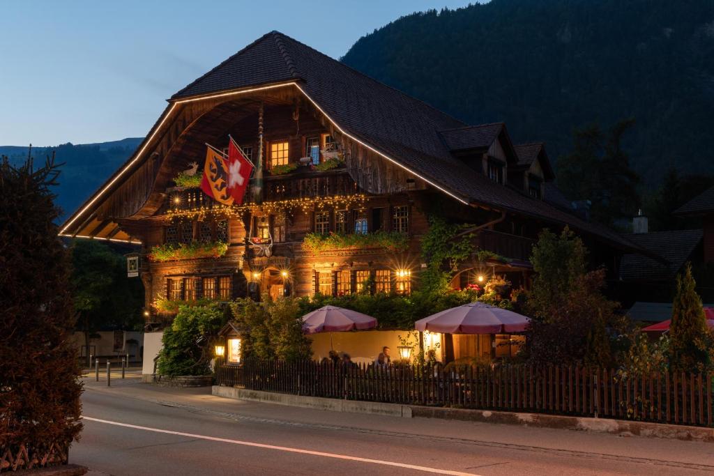 a large wooden building with umbrellas in front of it at Hotel Restaurant Hirschen in Interlaken