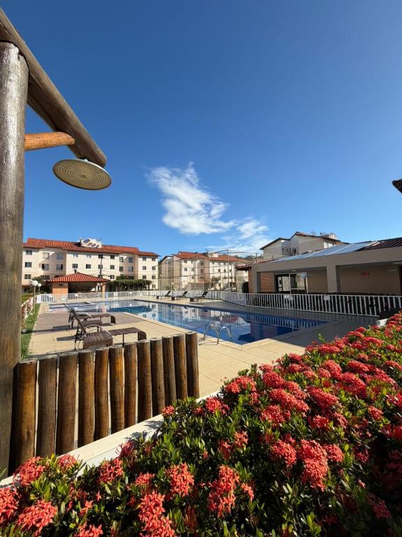 a view of a swimming pool with buildings and flowers at Apê mar e descanso com piscina no VOG JOÃO DE GOES ILHÉUS BA in Ilhéus