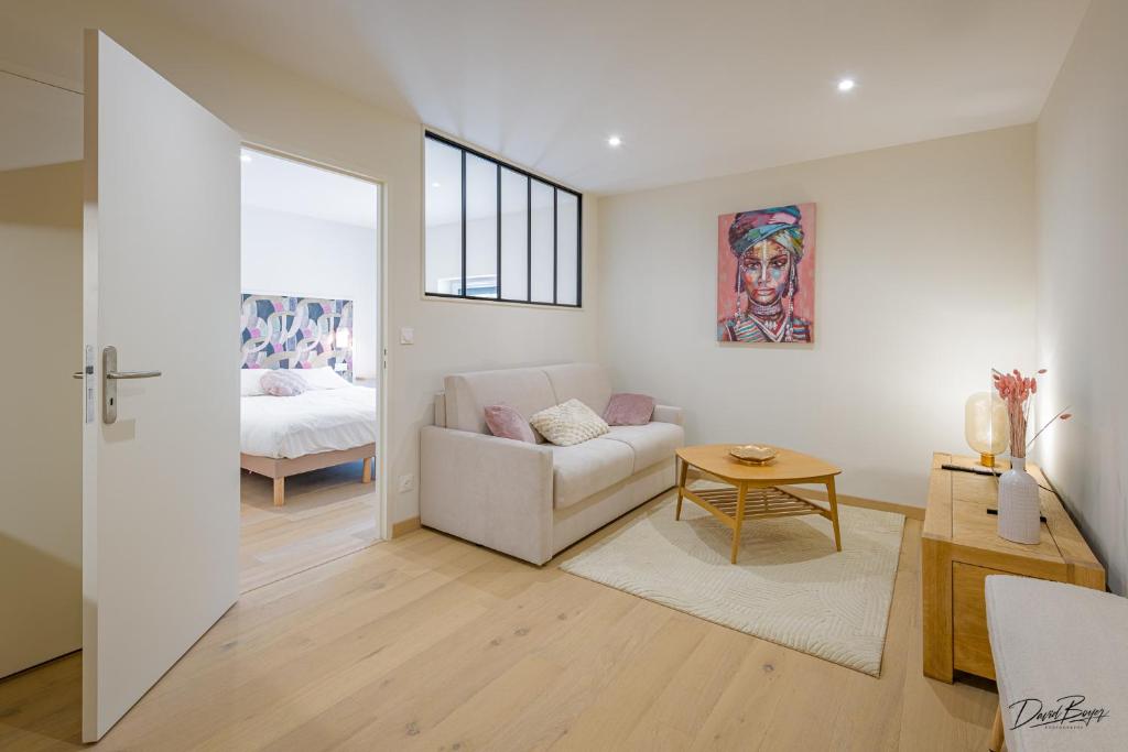 a living room with a couch and a bed at Domaine de cézille-Appart hotel le Moulin du lac in Jayat
