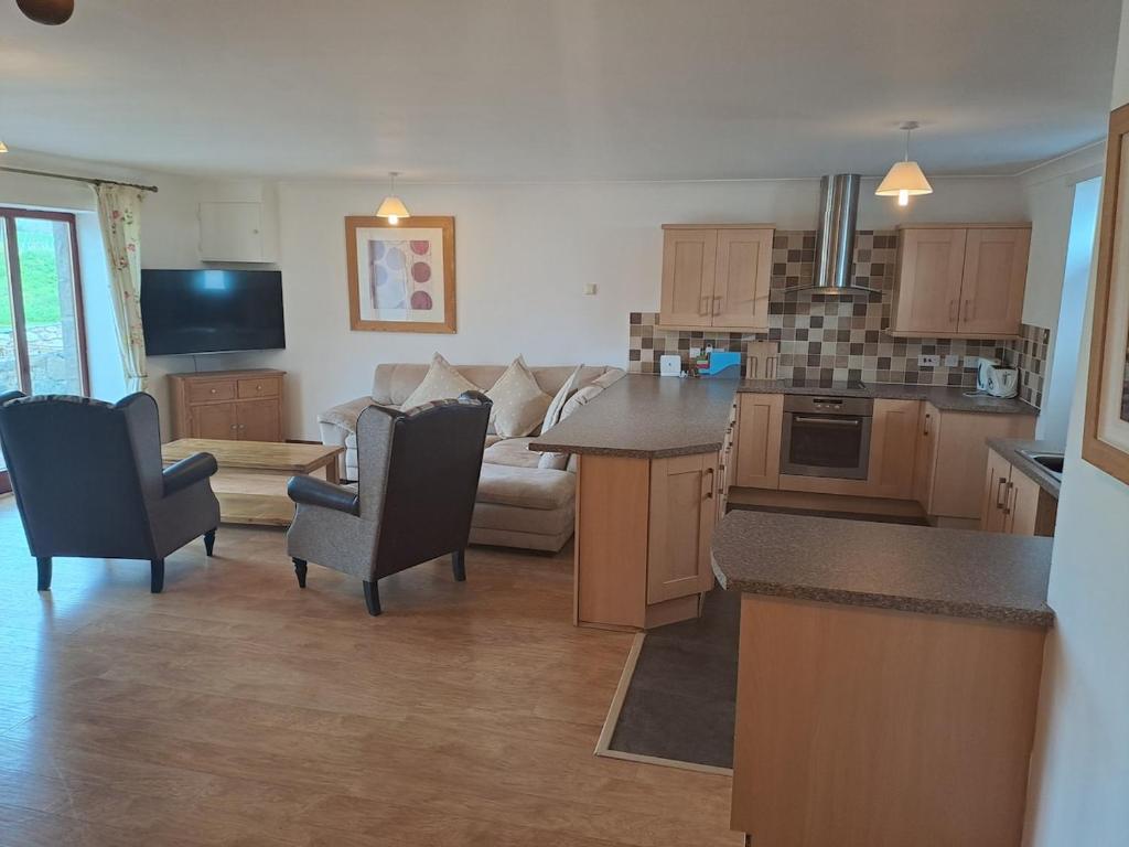 a large kitchen and living room with a couch at Glen Lyon in Inverurie