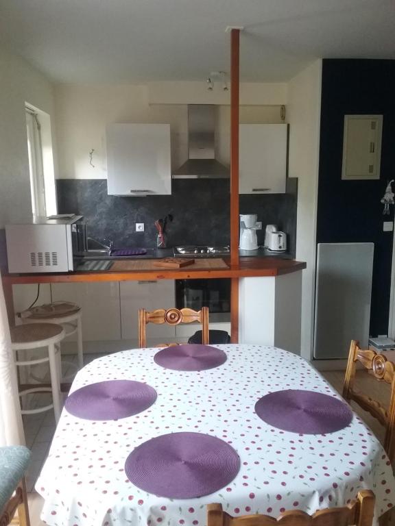 a kitchen with a table with purple plates on it at Studio in La Trinité-sur-Mer