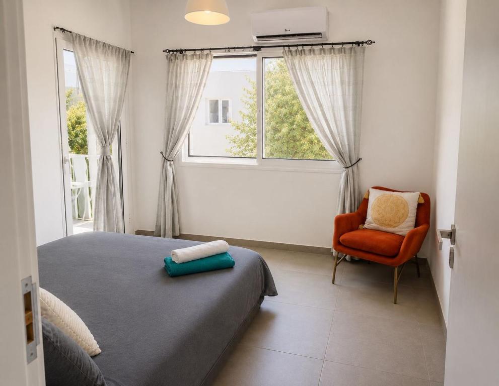 a bedroom with a bed and a chair and a window at Luxury hideaway in Larnaca