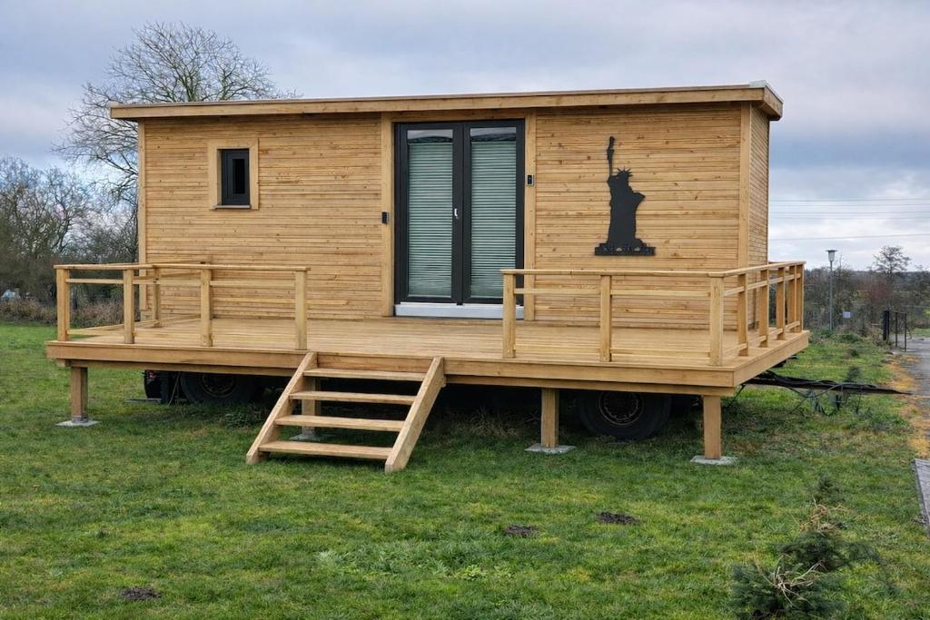 a tiny house with a cat on the deck at Tinyhaus auf dem Forsthof in Trinwillershagen