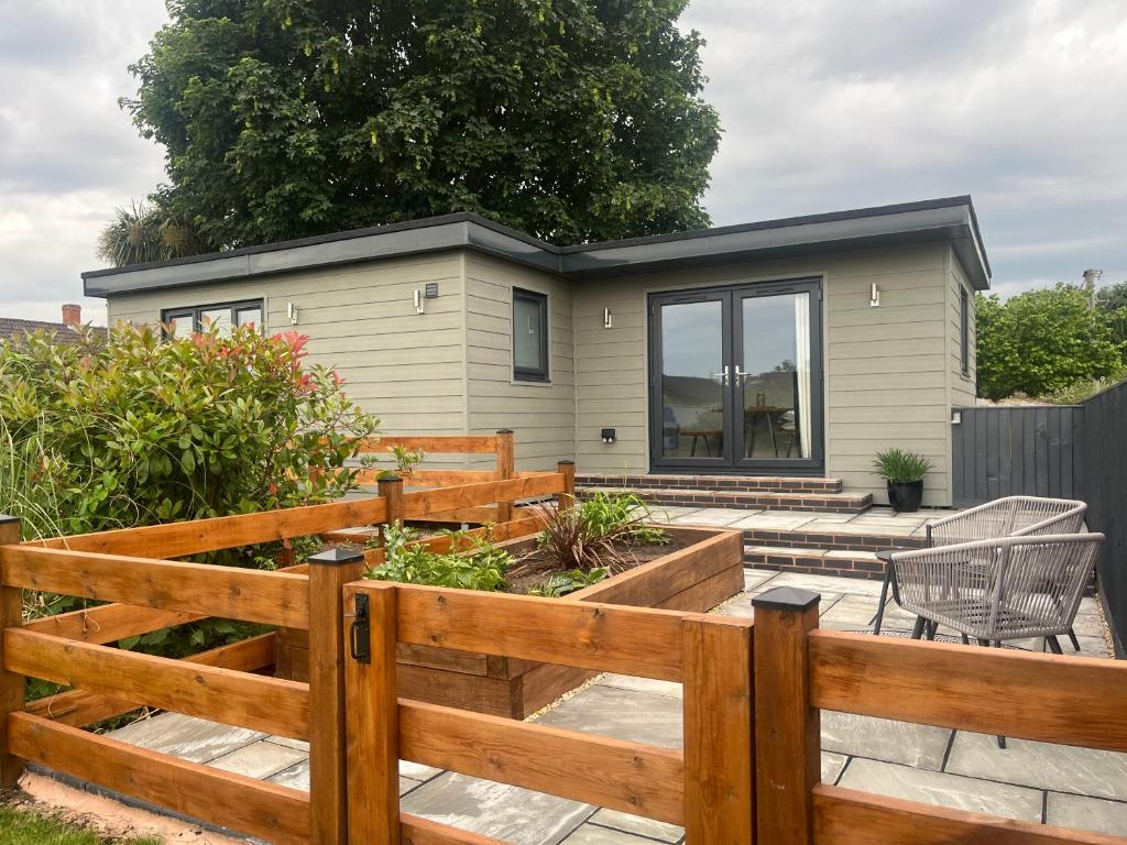 a backyard with a wooden fence and a tiny house at Riverside Lodge in Creech Saint Michael