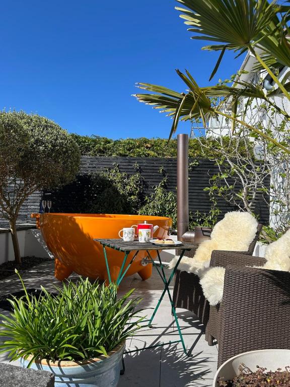 a patio with an orange tub and a table and chairs at The Seahorse Torbay in Torquay
