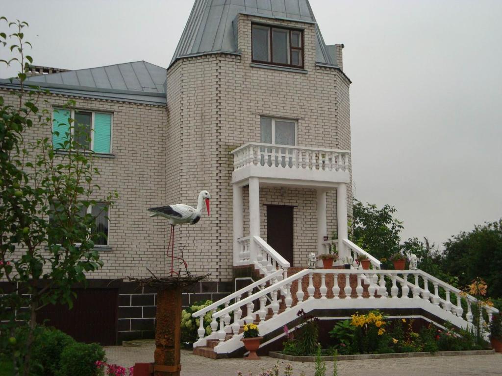 a house with a bird standing on the front of it at Agrousadby Veronika in Borisovo
