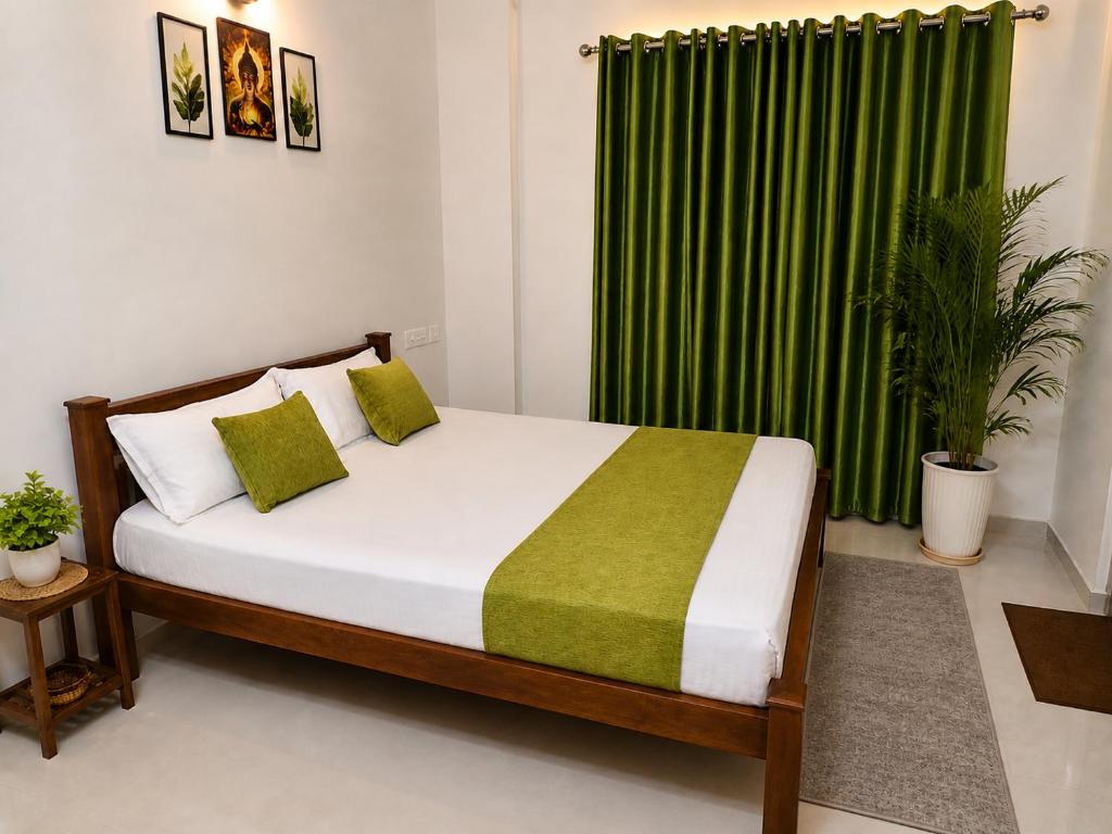 a bedroom with a bed with a green curtain at Krishna Theeram 150m from Temple in Guruvāyūr