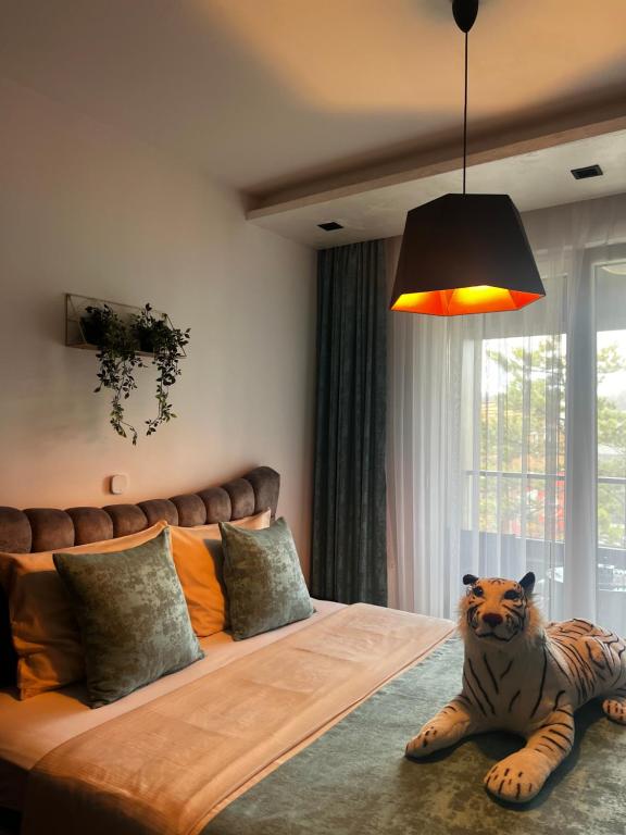a bed with a tiger statue sitting on the floor at Emma Park Lake Emma Parklake in Tuzla