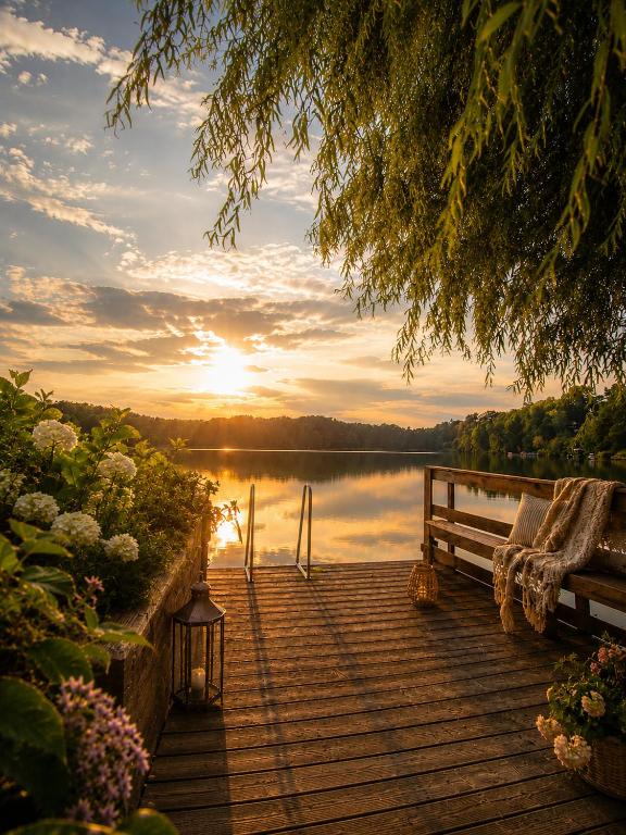 a wooden dock with a bench and a view of a lake at Das Seehaus Buckow in Buckow
