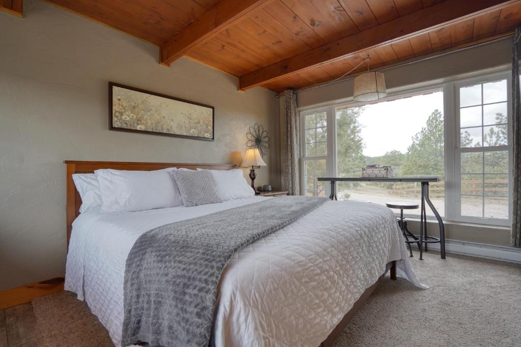 a bedroom with a bed and a table and a window at Sunrise Cabin at Highland Meadows - King Bed and Views in Hot Springs