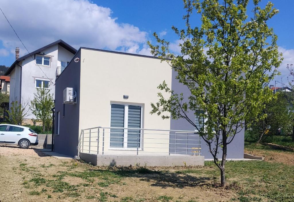 a white house with a tree in front of it at Apartment D&E in Sarajevo