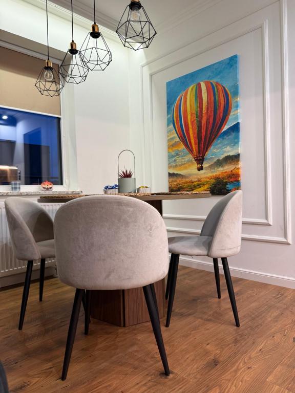 a dining room with a table and a hot air balloon painting at Katerina - Mona Luxury Apartments in Lębork