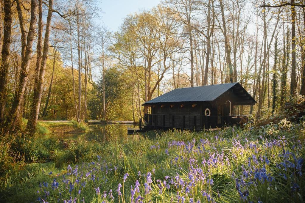 a black barn with a black roof in a field of flowers at Yogi's Cabin in Battle