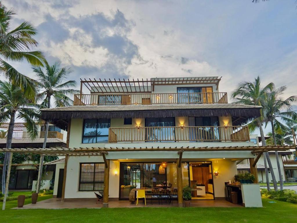 a large house with a balcony and palm trees at Casa Baião in Fortim