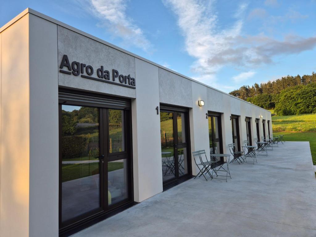 a building with a row of tables and chairs at Pensión Agro da Porta in Palas de Rei