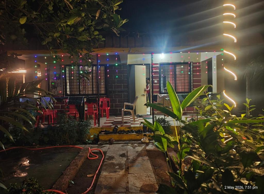 a house with a lit up patio at night at Dikshit bungalow in Diveagar