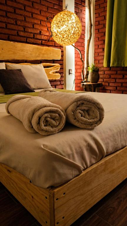 a wooden bed with towels on it in a bedroom at Hotel Spa Chignahuapan Mágico in Chignahuapan