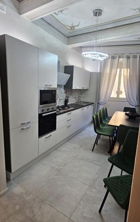 a kitchen with white cabinets and a table and chairs at HOUSE Sant'Angelo in Acquapendente