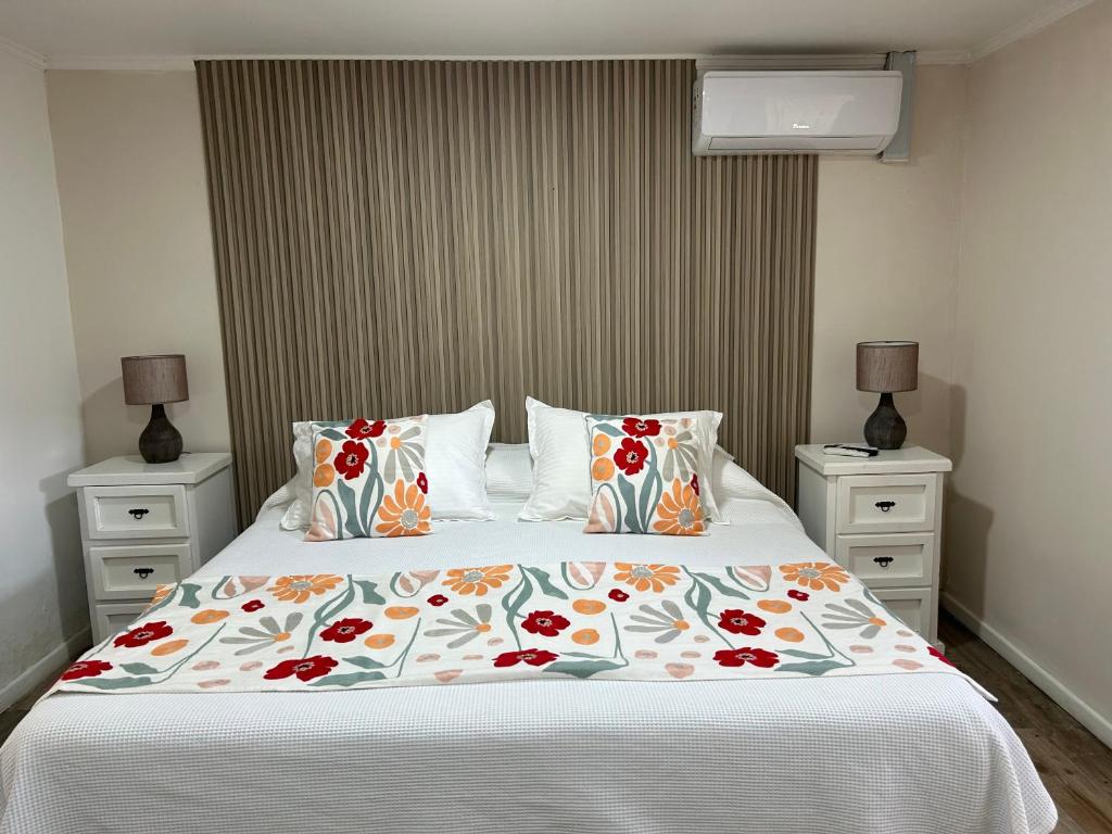a bedroom with a large bed with a floral bedspread at Hostal Doñihue in Doñihue