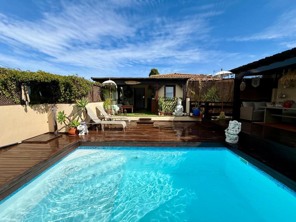 a large blue swimming pool in front of a house at Bungalow Aloha, Piscina Privada, Playa y Barbacoa in Benalmádena