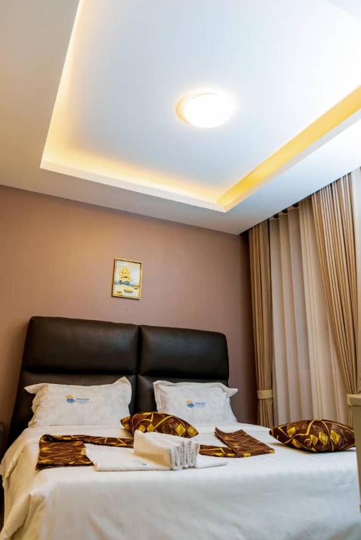 a bedroom with a large bed with a black headboard at Travellers Palace Hotel in Kampala
