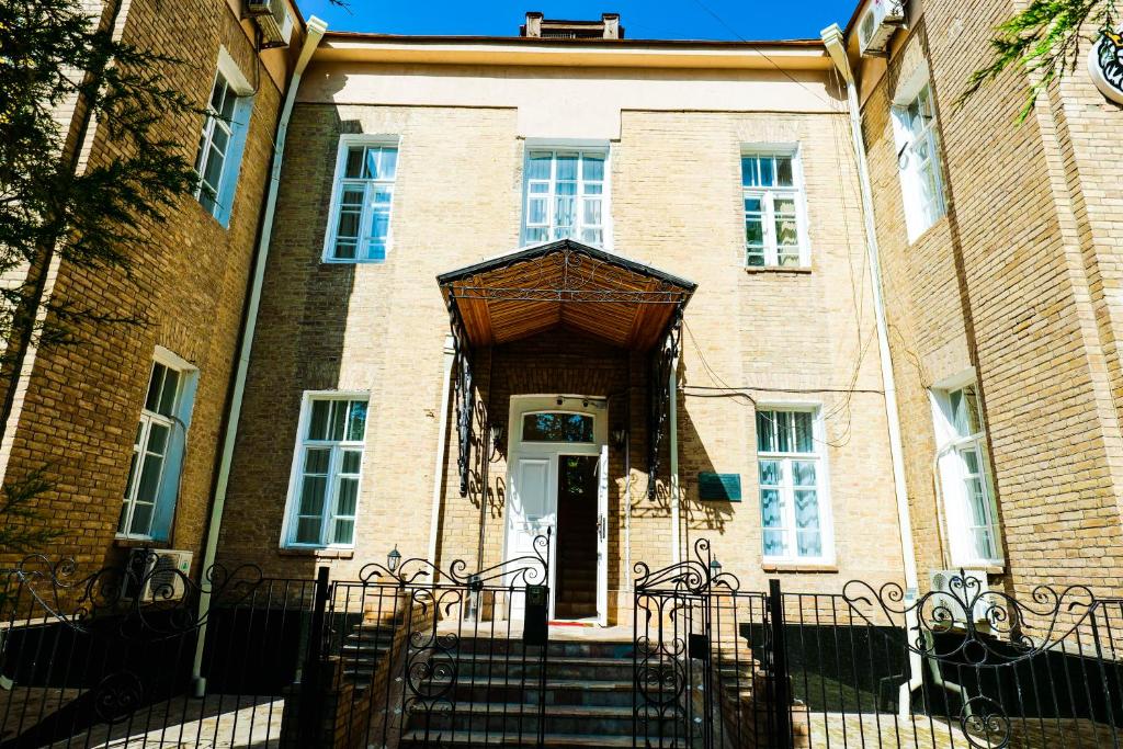 a brick building with stairs leading to the front door at Officers Boutique Hotel in Samarkand